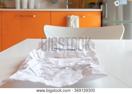 A Crumpled Sheet Of Paper With A Diet On A Kitchen Table.