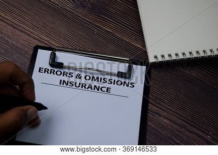 Errors & Omissions Insurance Write On Paperwork Isolated On Wooden Table.