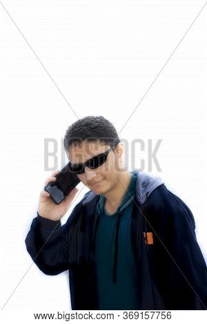 Portrait Shot Of A Hipster Male With A Smile On His Face Talking On Cell Phone Wearing Black Sunglas