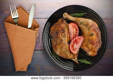 Chicken Thigh With Vegetables On Purple Wooden Background. Chicken Leg On Blac Plate With Fork And K