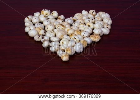 Makhana Also Know As Lotus Seeds Are Arranged Or Grouped In Heart Shape On Brown Wooden Table Shows 