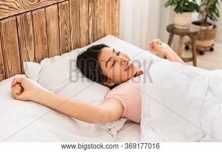 Wellslept Korean Woman Waking Up Stretching Lying With Eyes Closed In Bed At Home On Lazy Weekend Mo