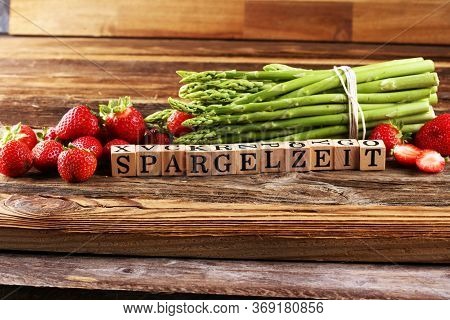 Healthy Fresh Green Asparagus And Strawberries On Vintage Background With The German Word Spargelzei
