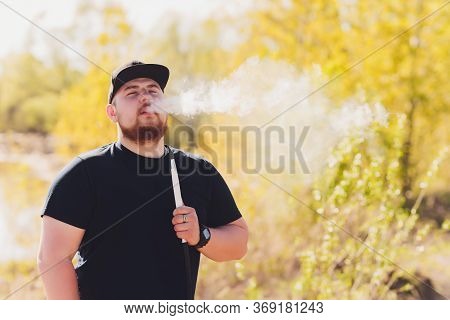 Man Smoking Shesha, Hookah Near The Lake Alone.