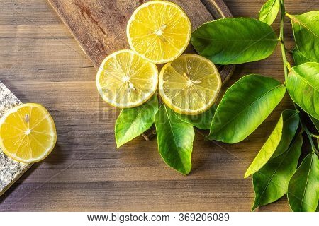 Top view of lemon and green leaves on wooden background