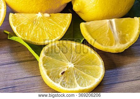 Top view of lemon and green leaves on wooden background