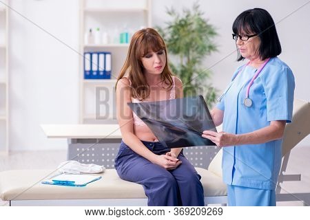 Young woman visiting old doctor oncologist in breast cancer