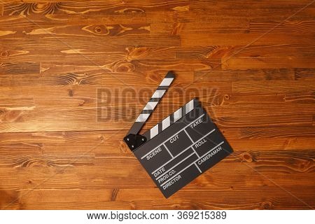 Movie Production Clapper Board Over Wooden Background. Top View. Copy Space.