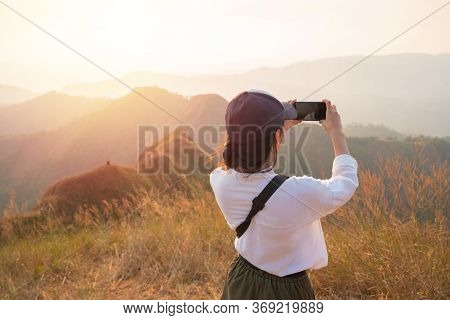 Traveler Female With Camera Smart Phone And Taking Photo Enjoying In The Mountains At Khao Chang Pua