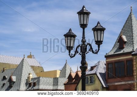 Street Lamppost Against The Old Buildings Background. Classic Victorian Street Lamps On An Old Fashi