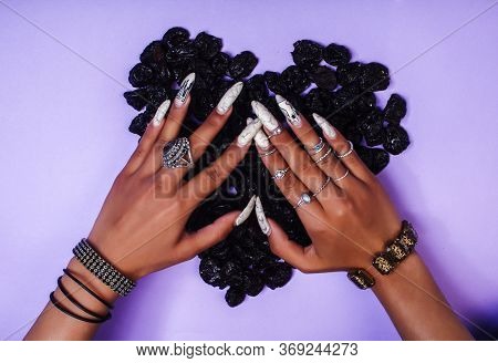 Woman Hands With Long Nails Manicure Holding Dry Fruits In Shape Of Heart On Purple Background