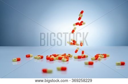 Yellow-orange Capsules Pill Falling Down On White Table. Pharmaceutical Industry. Tranexamic Acid Ca