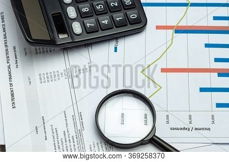 Single Magnifying Glass With Calculator, Leaning On The Financial Data. Business And Finance Concept