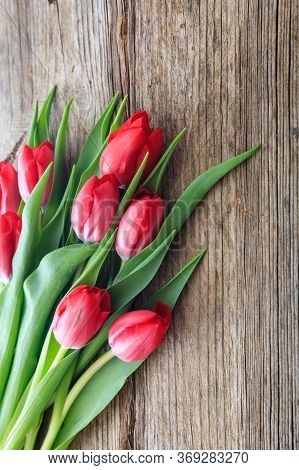 Red Tulips Bouquet Isolated On Wooden Background
