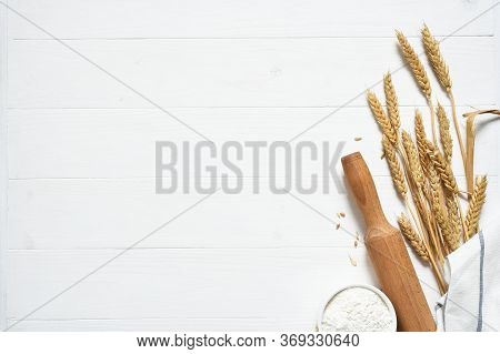 Baking Background With Flour, Wheat Ears And Rolling Pinon Concrete Background. Top View With Copy S