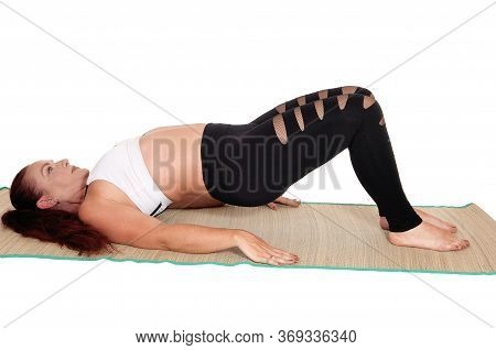 A Middle Age Woman In Sports Outfit Lying On The Back Lifting Her Butt
Up, With Her Red Hair And Nic