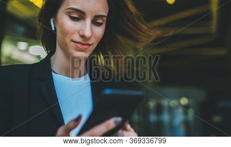 Successful Female Banker Using Wireless Earphones And Pushig Massage With Office News Outdoors Backg