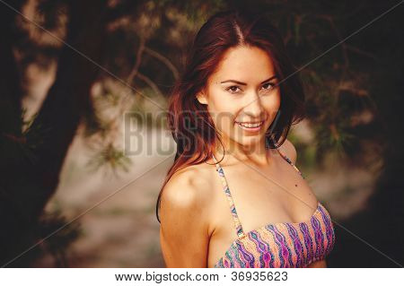 Smuk pige i en bikini på en baggrund en fyrreskov.