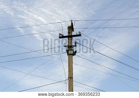 Pillar With Wires Against The Sky. Concrete Pole With Lots Of Wires And Led Spotlights. Industry, El