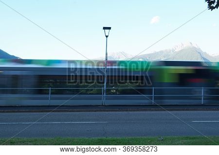 Colourful Photography, A Blurred Regional Train In Merano, South Tirol, Italy. Peak Ifinger On The R