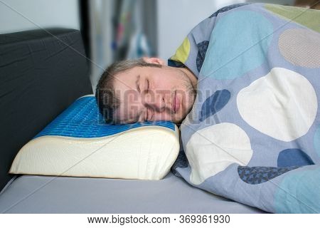 Men Lying On Bed With Orthopedic Pillow. Healthy Posture Concept. Latex Pillow With Memory Foam Effe