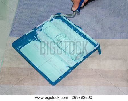 Plastic Tray With Turquoise Paint And Soft Dirty Paint Roll Brush In Mint Paint. Tools For The Paint