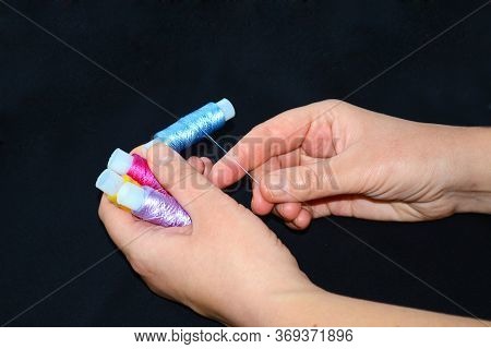 Female Hands Hold Skeins Of Thread. Silk Threads For Embroidery. Yellow, Lilac And Pink Skeins In Th