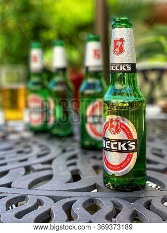 Southampton, UK - 2nd June 2020: Becks beer bottles on a garden table during an early summer hot spell of sunny weather.