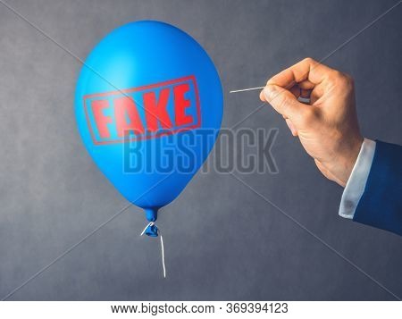 Concept Of Fake Information. Blue Balloon. Man Hold Needle Directed To Air Balloon. Idea Of Disinfor