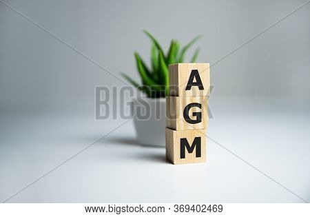 Agm Annual General Meeting Acronym On Wooden Cubes On Dark Wooden Backround. Business Concept.