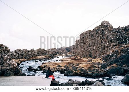 A Girl In A Red Dress Near Ehsaraurfoss Falls, Ehsarau River, National Park, Tingwedlir, Sudurland R