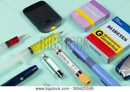Various Elements Of Medicine On A Green Background And A Tube Of Blood Test For Covid-19. Box Write 