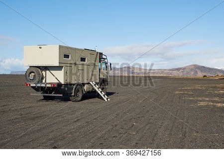 Vik, Iceland - Circa 2018: Big expedition camping truck on an Icelandic black sand volcanic outwash plain at Hjorleifshofdi