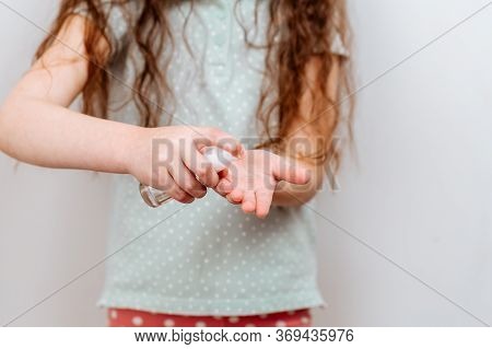 The Child Uses A Hand Sanitizer. Antibacteria Spray To Prevent Spread Of Germs, Bacteria And Virus. 