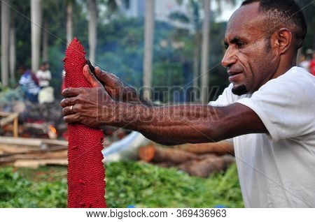Jakarta, Indonesia - May 25, 2014 : Papua People Peeling Red Fruit At The Festival Papua In Monas, J