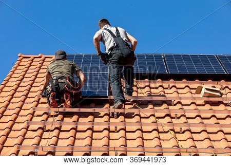 Ochojno, Poland - April 8, 2020: Workers Installing Solar Electric Panels On A House Roof In  Ochojn