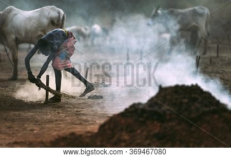 Mundari Tribe, South Sudan - March 11, 2020: Man Swinging Bunch Of Twigs And Spreading Smoke Near He