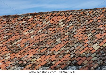 Pantiles. Closeup Of A Roof With New And Old Terracotta Tiles (coppo In Italian Language), On A Blue