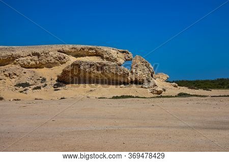 Rocky Formation In The Desert With Blue Sky Above And Hot Sun Shining Down From Above