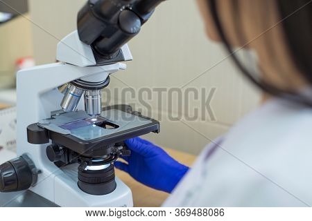 Laboratory Assistant Is Looking Through A Microscope. Close-up Doctor Laboratory Assistant Looking T