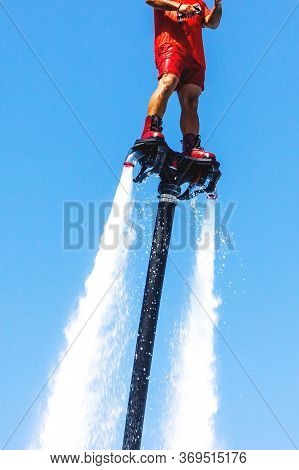 Fly Board, Man On A Flyboard In Red. Water Extreme Sport. The Guy Is Flying At The Aquatic Flyboard.