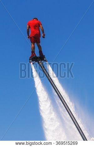 Fly Board, Man On A Flyboard In Red. Water Extreme Sport. The Guy Is Flying At The Aquatic Flyboard.