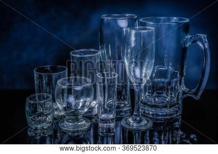 Glass Drinkwares And Stemwares Of Different Shapes And Sizes Stand Side By Side On An Isolated Black