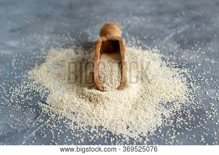 Raw Uncooked Fonio Seeds With A Spoon On Grey Background Close Up