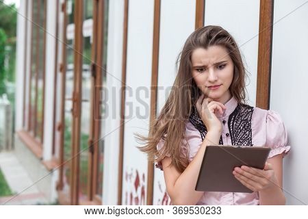 Shocking News. Closeup Portrait Shocked Girl Looking At Pad Reading Bad News. Young Funny Woman Star