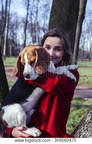 Pretty Young Girl In Redd Coat Playing With Dog Outside In Green Park, Lifestyle People Concept