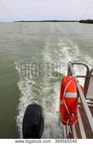 Boat With Life Preserver Sails Fast Towards The Mouth Of The Great River