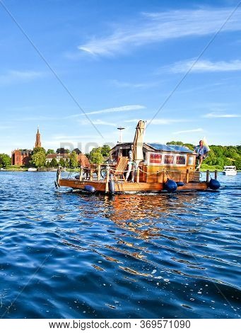 Malchow, Germany - July 9, 2017: A Man Navigates A Houseboat Across The Malchower See In The German 