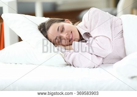 Happy Girl In Pajamas Lies In Bed Closing Her Eyes. Woman Is Disturbed By Insomnia, Normalization Sl