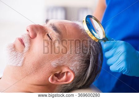 Old man visiting young male doctor in hair transplantation conce